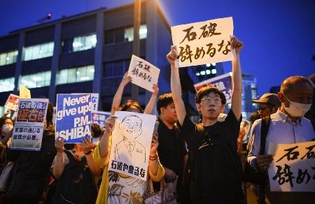 　「石破辞めるな」のプラカードを掲げる人たち＝７月25日、首相官邸前