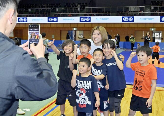 子どもたちと笑顔で記念撮影をする鏡選手（中央奥）＝21日午後５時35分、宇都宮市元今泉５丁目