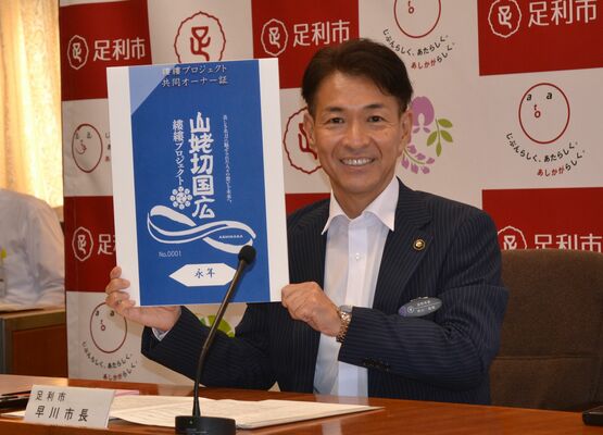 オリジナルオーナー証のデザインを発表する早川市長