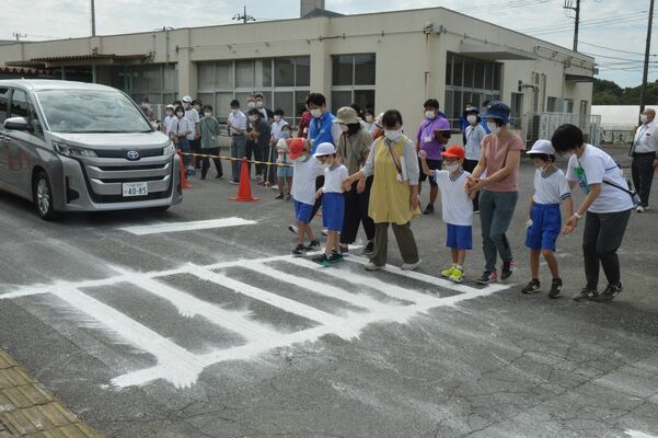 車両接近通報音を聞き分けながら横断体験をする子どもたち