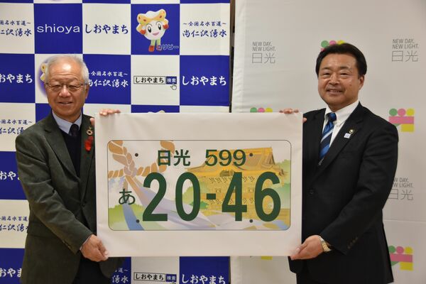 国交省に提案する日光ナンバーの図柄を手にする粉川市長（右）と見形町長