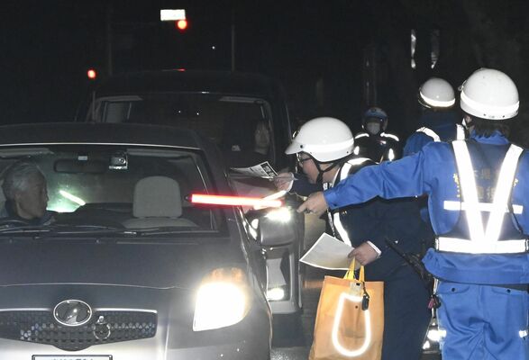 多発する交通死亡事故を受け、検問を強化する警察官＝23日午後７時５分、真岡市大谷台町
