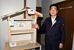 「遮熱健康住宅」体感試験棟の模型で遮熱機能を説明する野口社長＝足利市