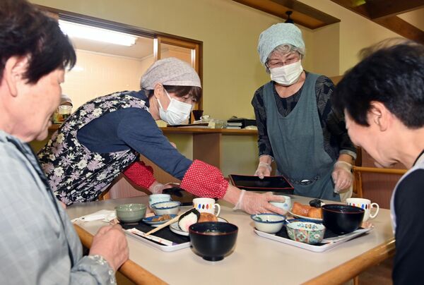 配膳する足尾地区更生保護女性会のメンバー。「気軽に立ち寄ってもらえる居心地の良い場所にしたい」と来客を温かく迎える=4日午前、日光市足尾町