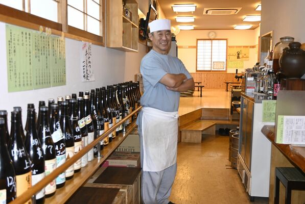 常連のボトルが並ぶ店内と店主の諏訪さん