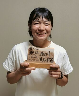 ４位入賞の盾を手に笑顔の助川さん
