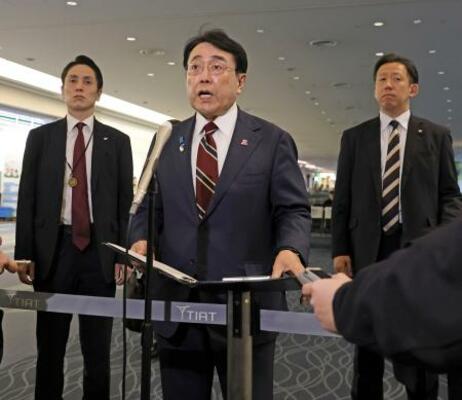 　出発前、羽田空港で記者団の取材に応じる赤沢経産相（中央）＝１１日午前