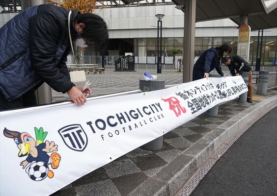 横断幕を設置する市職員ら