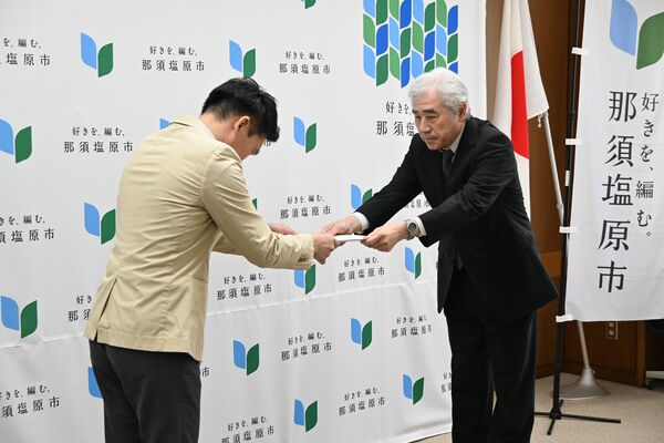 渡辺市長（左）に答申書を手渡す太田会長