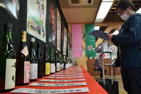 資料を見ながら酒を選ぶ客ら