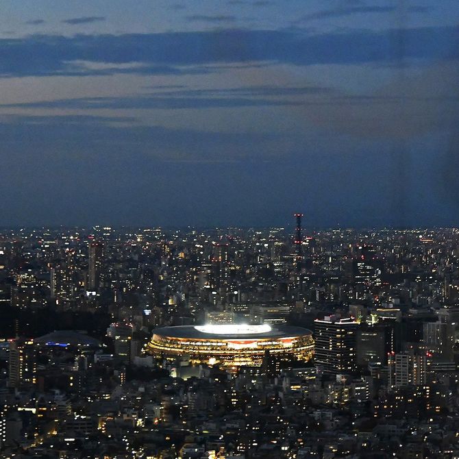 陸上競技が行われ明かりがともる国立競技場＝７月31日午後、東京都渋谷区