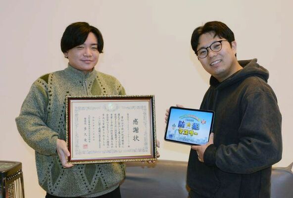 大阪府警からの感謝状を手にする斎藤常務取締役（左）と八木沢さん＝２０２５年１２月、宇都宮市錦２丁目