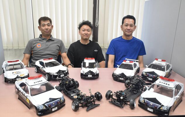県警の車両をモデルにラジコンパトカーを製作している千葉さん（左端）と吉井さん（中央）、今さん＝８月16日午後、下野新聞社