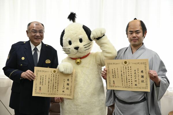 感謝状を手にするニャンまげ（中央）と江戸村の町人（右）、木川署長