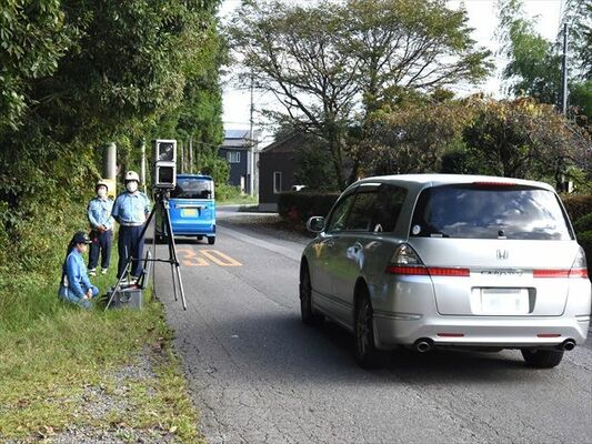 可搬オービスで通行車両の速度違反取り締まりを行う警察官＝29日午前、日光市木和田島（画像は一部加工しています）