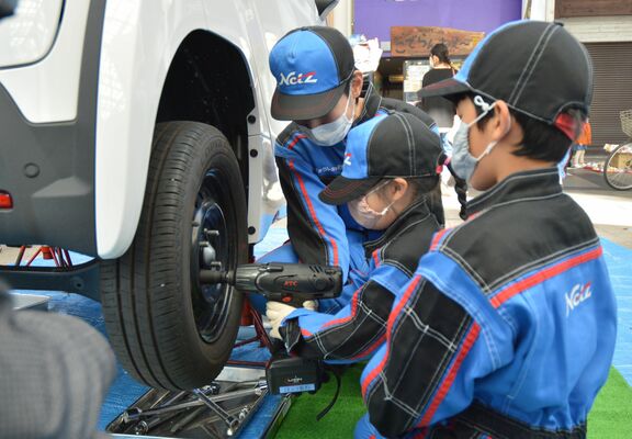 自動車整備士の仕事を体験する子ども＝４日午前、宇都宮市内