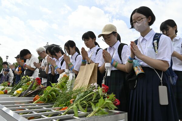 ６年ぶりの平和記念式典派遣となった日光市の中学生。真剣な表情で原爆慰霊碑に手を合わせた＝６日午前、広島市中区