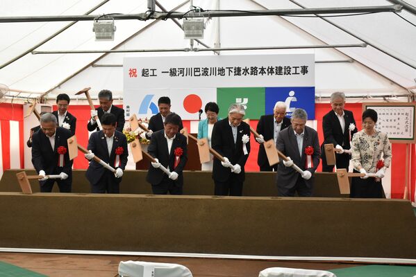 起工式でくわ入れを行う出席者
