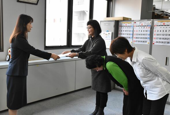 県教委の玉田特別支援教育課長（左）に意見書を提出する保護者ら＝17日午前、県庁南別館