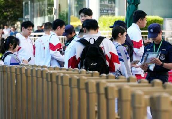 中国の全国一斉大学入試「高考」の会場前で所持品をチェックされる学生=7日、北京(共同)
