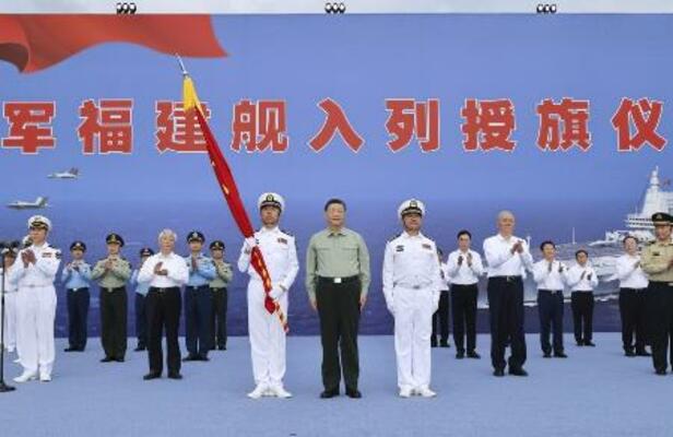 中国軍の新型空母「福建」が就役し、式典に臨む習近平国家主席(手前中央)=5日、中国海南省三亜市(新華社=共同)