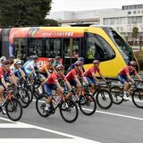 “赤いＬＲＴ”とブリッツェン選手が並走　沿線でクリテリウム　ラッピング電車で「赤い稲妻」演出
