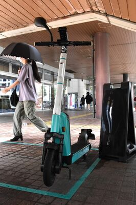 電動キックボードの正しい乗り方示す宇都宮市の担当者。ヘルメットをかぶって車道の左側を走行する＝30日午前、宇都宮市