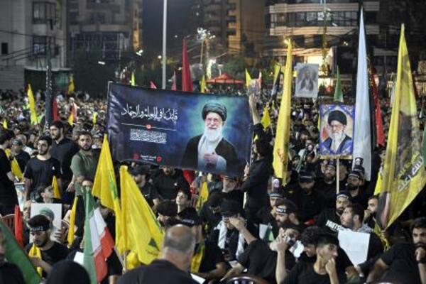 レバノンの首都ベイルートで、イランの前最高指導者アリ・ハメネイ師を追悼するため写真やイラン国旗を掲げる人々=8日(ゲッティ=共同)