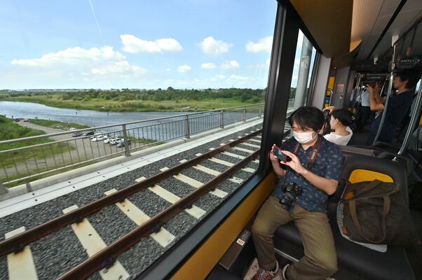 車窓から見える鬼怒川の風景などを取材する報道陣（超広角レンズ使用）