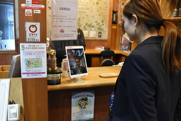 顔認証システムのデモンストレーションをする担当者
