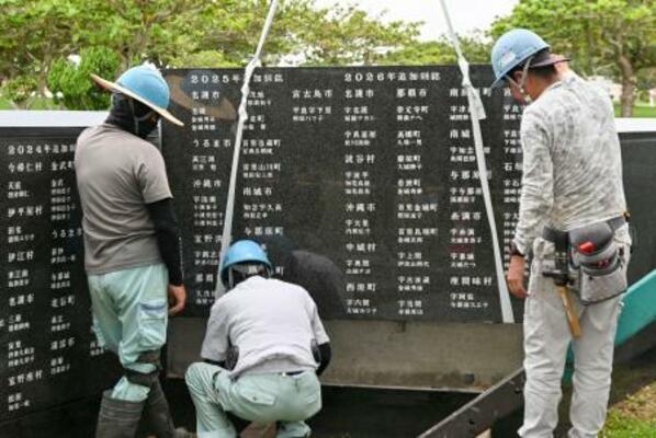 石碑「平和の礎」に刻銘板を設置する作業員=18日午前、沖縄県糸満市摩文仁の平和祈念公園