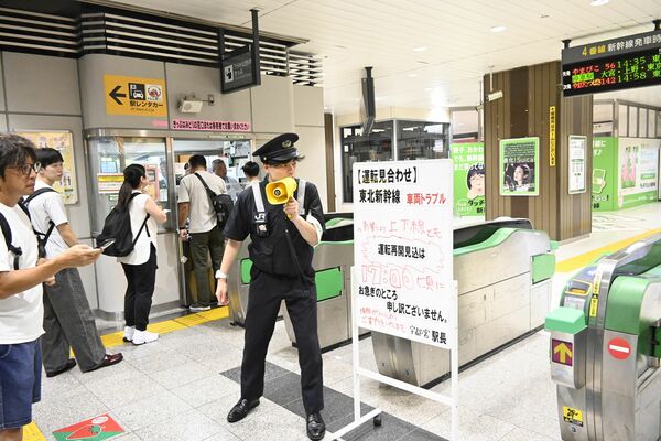 東北新幹線の運転再開見込み時刻を案内する駅員＝24日午後４時30分、ＪＲ宇都宮駅