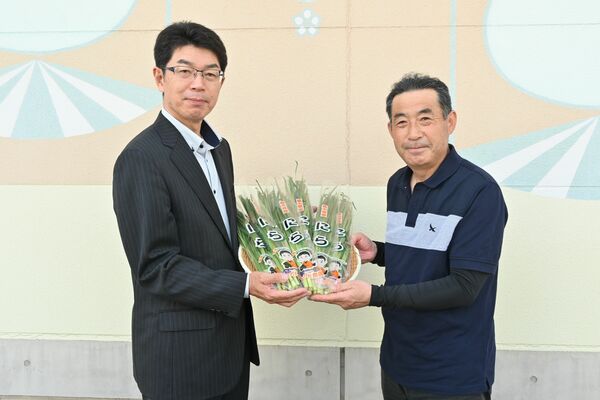 増渕教育長にニラを手渡す津野田さん（右）