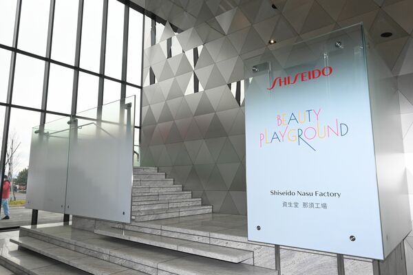 人の肌のキメをイメージした壁のある工場入り口