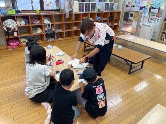 那須塩原市の大山やんちゃクラブで、子どもたちと名刺交換した橋本記者