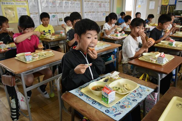 記念献立の給食を頬張る大幡間小の児童たち