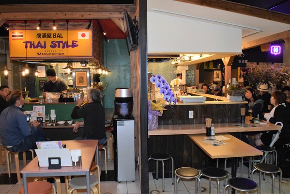 背中合わせに店舗が出店する屋内型屋台村「夜市横丁」＝８日夜、宇都宮市