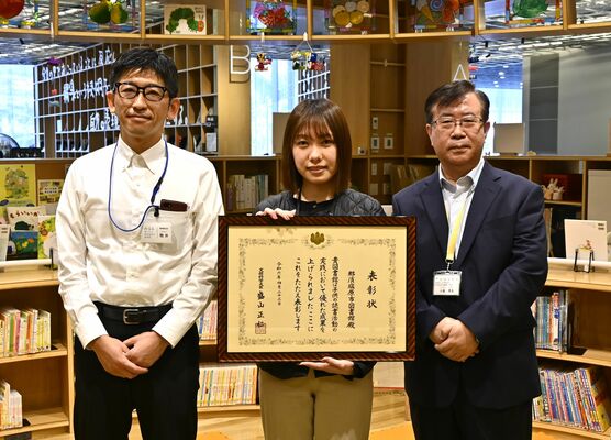 文部科学大臣表彰を受けた、みるるの小泉館長（右）と担当者ら