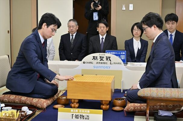 井山王座との対局で２手目を打つ一力棋聖（左）＝27日午前９時、日光市安川町