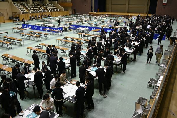 栃木市長選・市議選の開票作業に臨む職員ら＝19日午後８時すぎ、栃木市川原田町、稲毛萌撮影