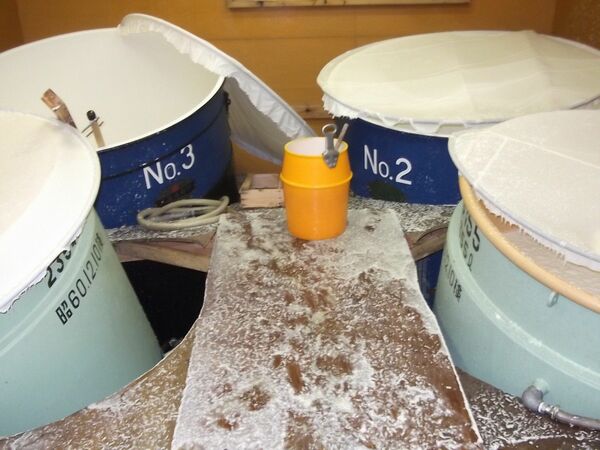 礎石から外れ、壁や足場にもたれかかる貯蔵庫のタンク（天鷹酒造提供）