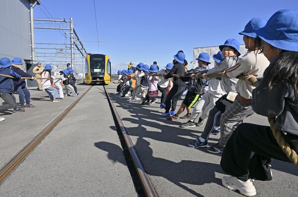 ＬＲＴと綱引きする平石中央小の児童＝９日午前10時20分、宇都宮市下平出町