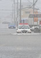 冠水した交差点を慎重に進むパトカー＝４日午後１時、宇都宮市横田新町