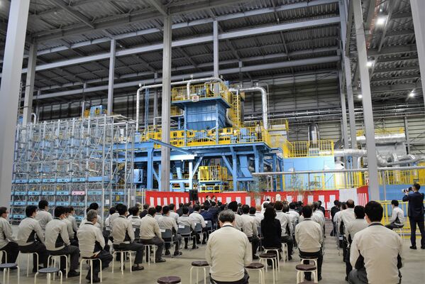 生産ラインの鋳造設備前で行われた竣工式＝１８日午前、足利市