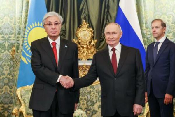 　１２日、モスクワで会談前に握手するロシアのプーチン大統領とカザフスタンのトカエフ大統領（左）（ロシア大統領府提供・タス＝共同）