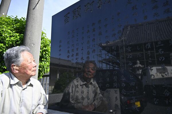 慰霊碑を眺める阿部さん。碑文を見ると、今でも戦時中の記憶がよみがえる=5月中旬、足利市百頭町