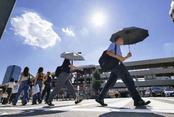 　昨年８月、最高気温４０度を観測した名古屋市で日傘を差して歩く人たち