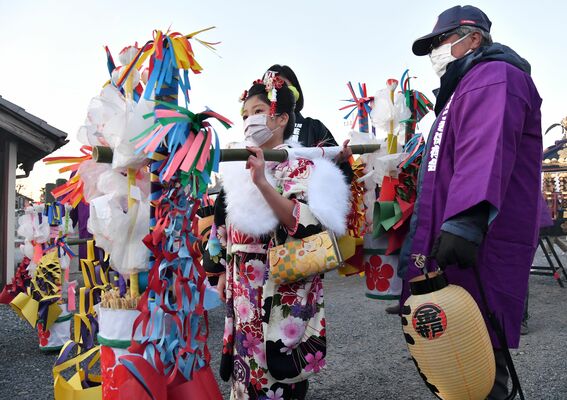 晴れ着姿で花桶をかついで練り歩く稚児＝28日午後４時55分、小山市寒川