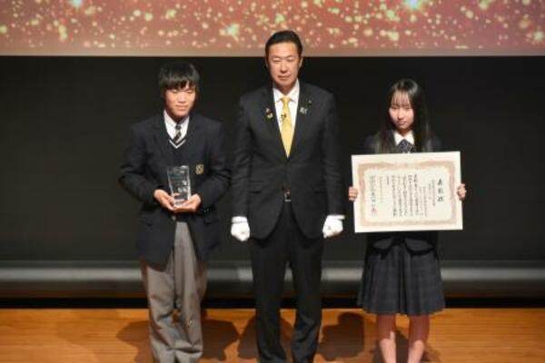 地方創生担当大臣賞に選ばれた、愛知県立猿投農林高校チームのメンバー。中央は黄川田地方創生相=6日午後、東京都千代田区