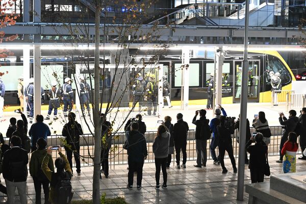 ＬＲＴの車両を見ようと集まった人たち＝１７日午後１０時４０分、宇都宮市宮みらい